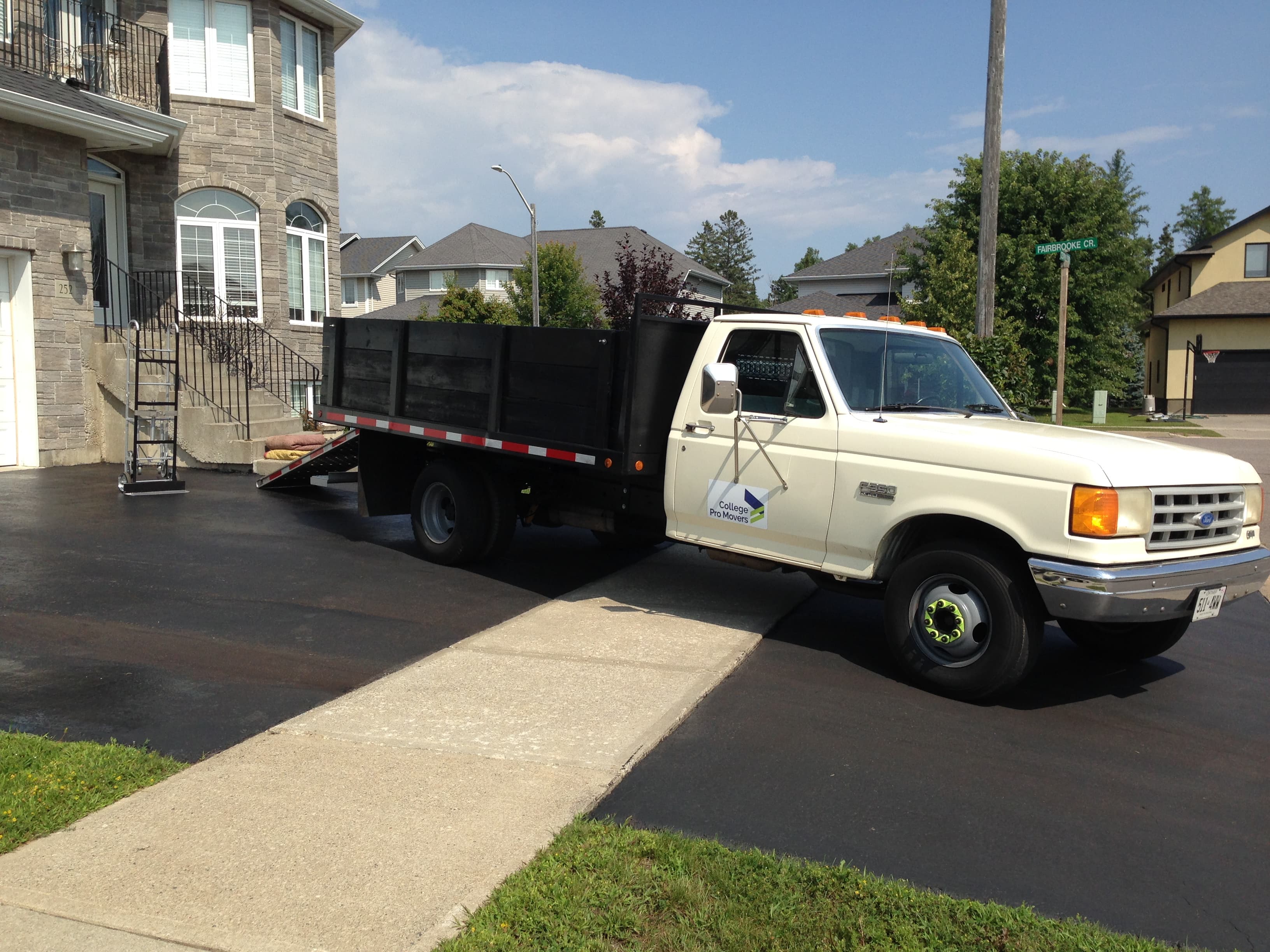 Junk removal truck parked in a residential driveway for a home cleanout
